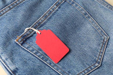 Photo of Cardboard tag on blue jeans, above view
