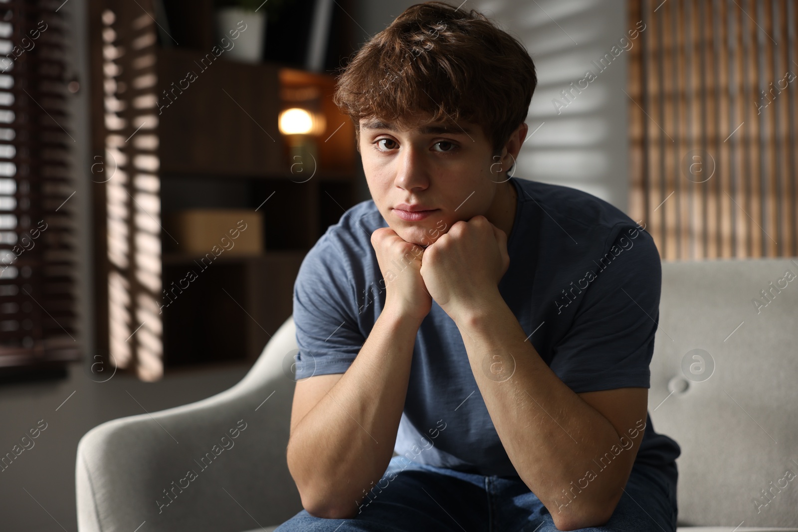 Photo of Teen problems. Upset teenage boy on sofa at home