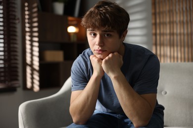 Photo of Teen problems. Upset teenage boy on sofa at home