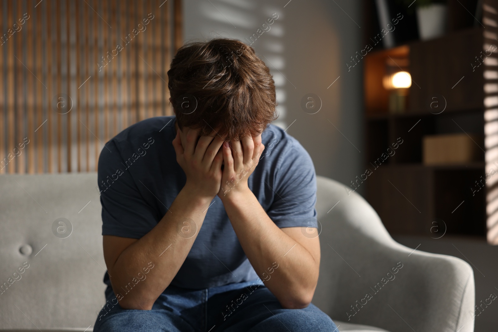 Teen problems. Depressed teenage boy on sofa at home Photo of Teen problems. Depressed teenage boy on sofa at home