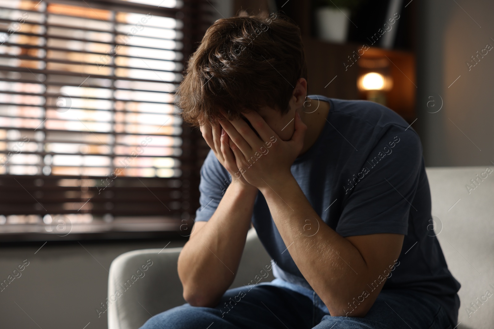 Teen problems. Depressed teenage boy on sofa at home Photo of Teen problems. Depressed teenage boy on sofa at home