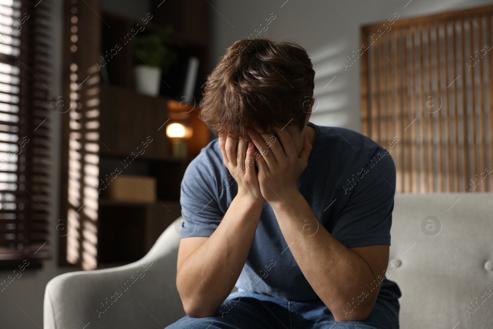 Teen problems. Depressed teenage boy on sofa at home Photo of Teen problems. Depressed teenage boy on sofa at home