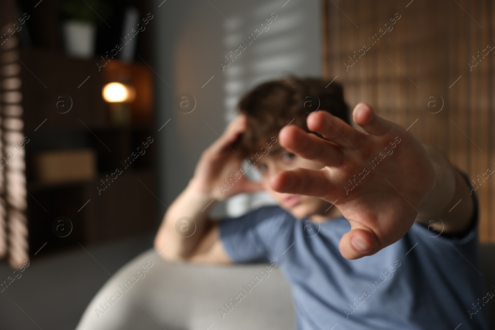 Teen problems. Upset teenage boy making stop gesture at home, selective focus Photo of Teen problems. Upset teenage boy making stop gesture at home, selective focus