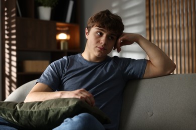 Photo of Teen problems. Upset teenage boy on sofa at home