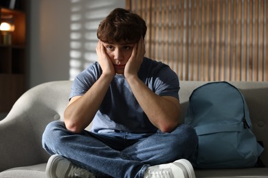 Photo of Teen problems. Upset teenage boy on sofa at home