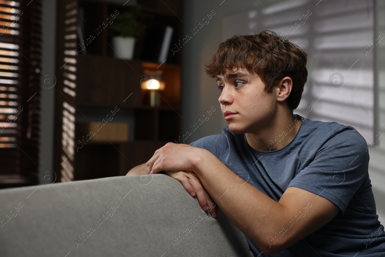 Teen problems. Upset teenage boy on sofa at home Photo of Teen problems. Upset teenage boy on sofa at home
