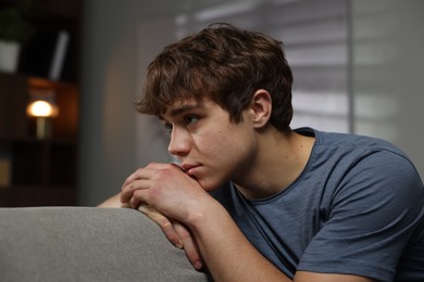 Photo of Teen problems. Upset teenage boy on sofa at home