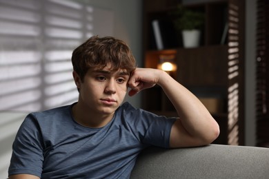 Photo of Teen problems. Upset teenage boy on sofa at home
