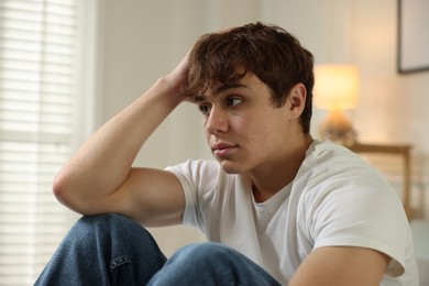 Photo of Teen problems. Upset teenage boy at home