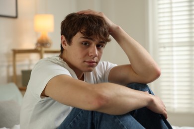 Photo of Teen problems. Upset teenage boy at home