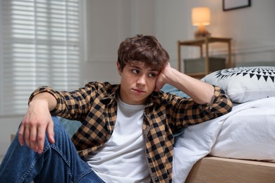 Photo of Teen problems. Upset teenage boy on floor at home