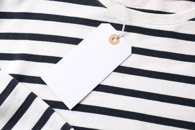 Photo of Cardboard tag on striped garment, top view