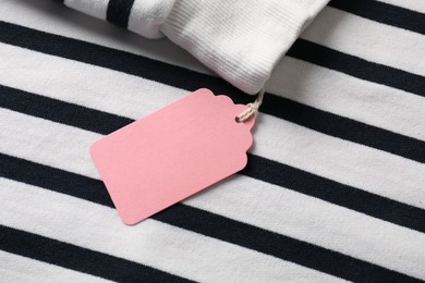Photo of Cardboard tag on striped garment, top view