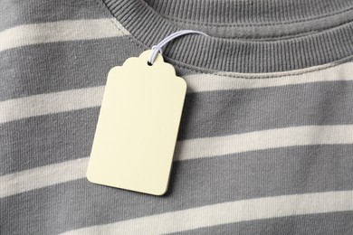 Photo of Cardboard tag on striped garment, top view