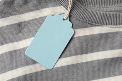 Photo of Cardboard tag on striped garment, top view