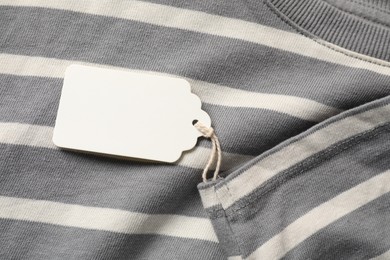 Photo of Cardboard tag on striped garment, top view