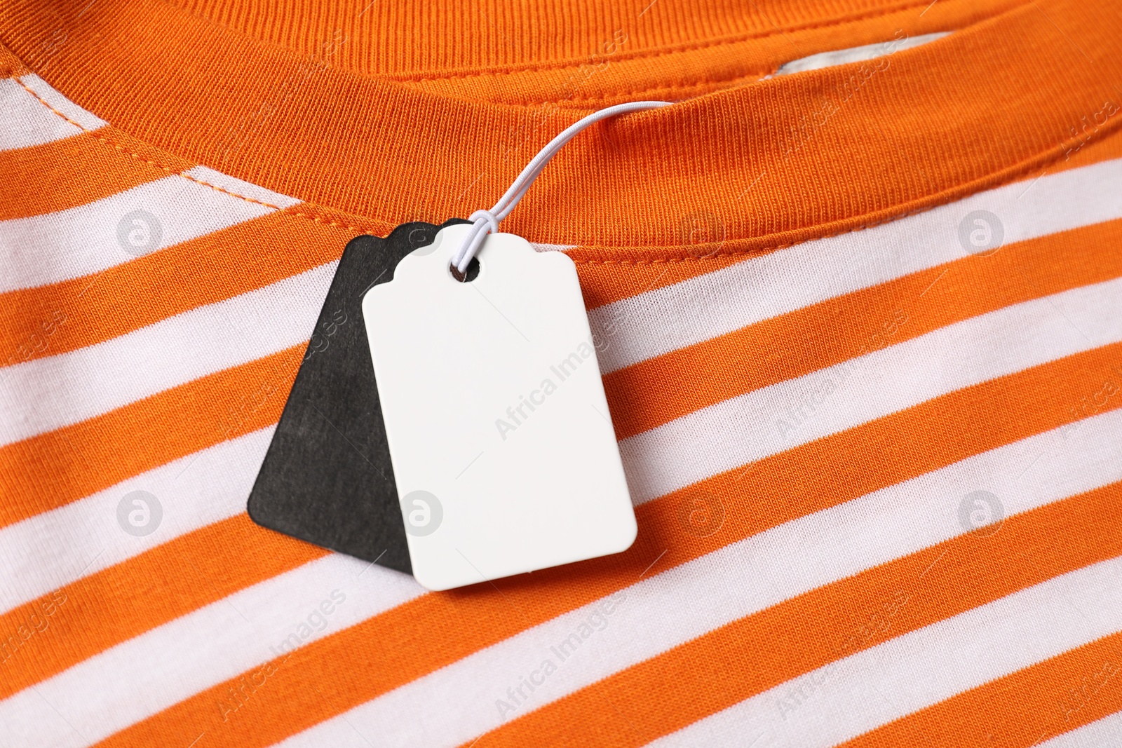 Cardboard tags on striped garment, top view Photo of Cardboard tags on striped garment, top view