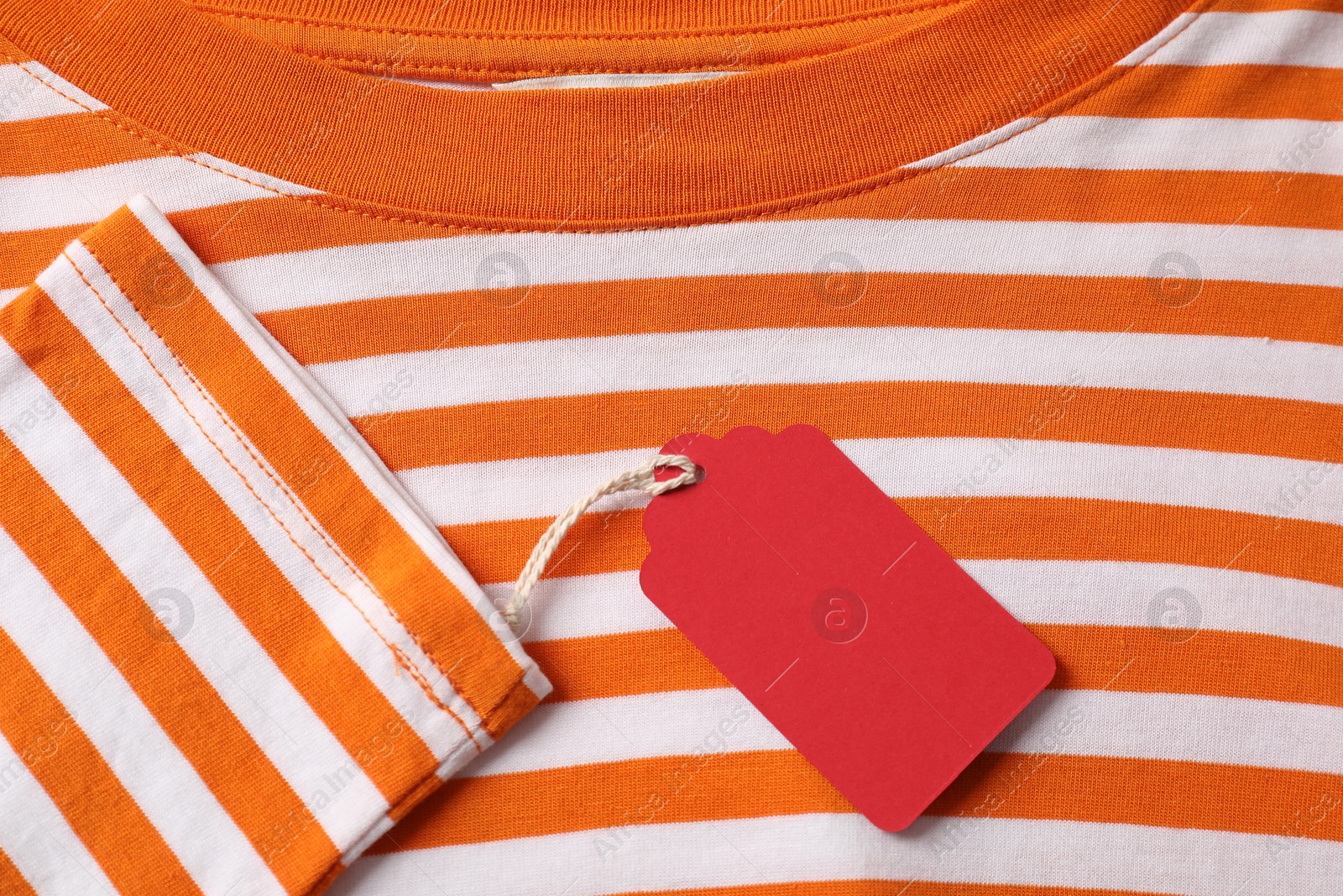 Cardboard tag on striped garment, top view Photo of Cardboard tag on striped garment, top view