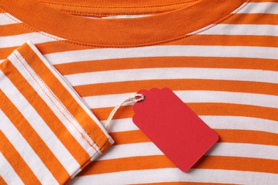 Photo of Cardboard tag on striped garment, top view