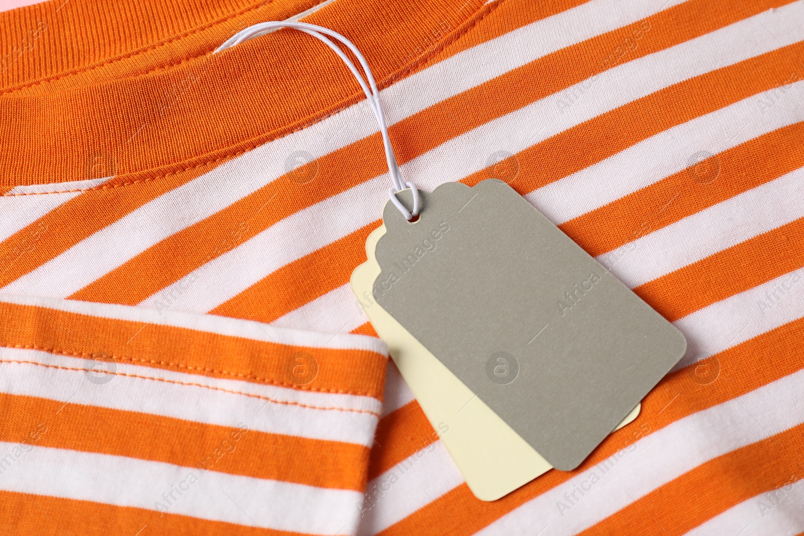 Cardboard tags on striped garment, above view Photo of Cardboard tags on striped garment, above view