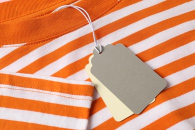 Photo of Cardboard tags on striped garment, above view