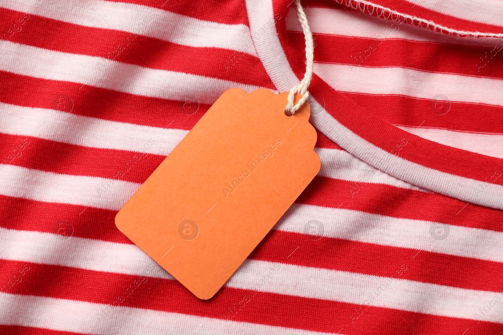 Photo of Cardboard tag on striped garment, top view