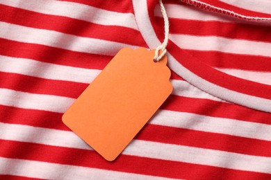Photo of Cardboard tag on striped garment, top view