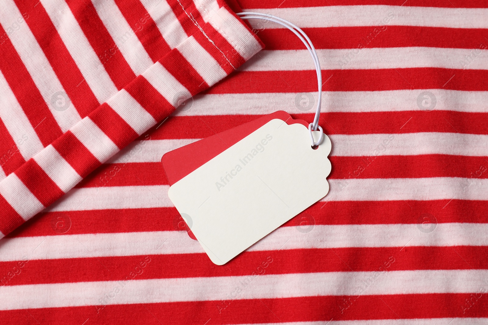 Cardboard tags on striped garment, top view Photo of Cardboard tags on striped garment, top view