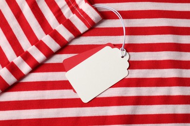 Photo of Cardboard tags on striped garment, top view