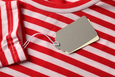 Photo of Cardboard tags on striped garment, top view