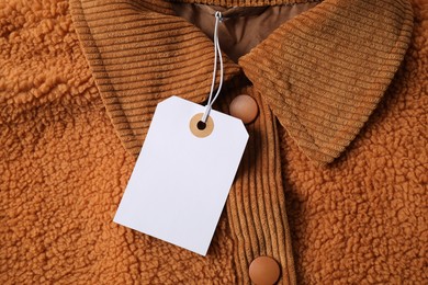 Photo of Cardboard tag on brown garment, top view