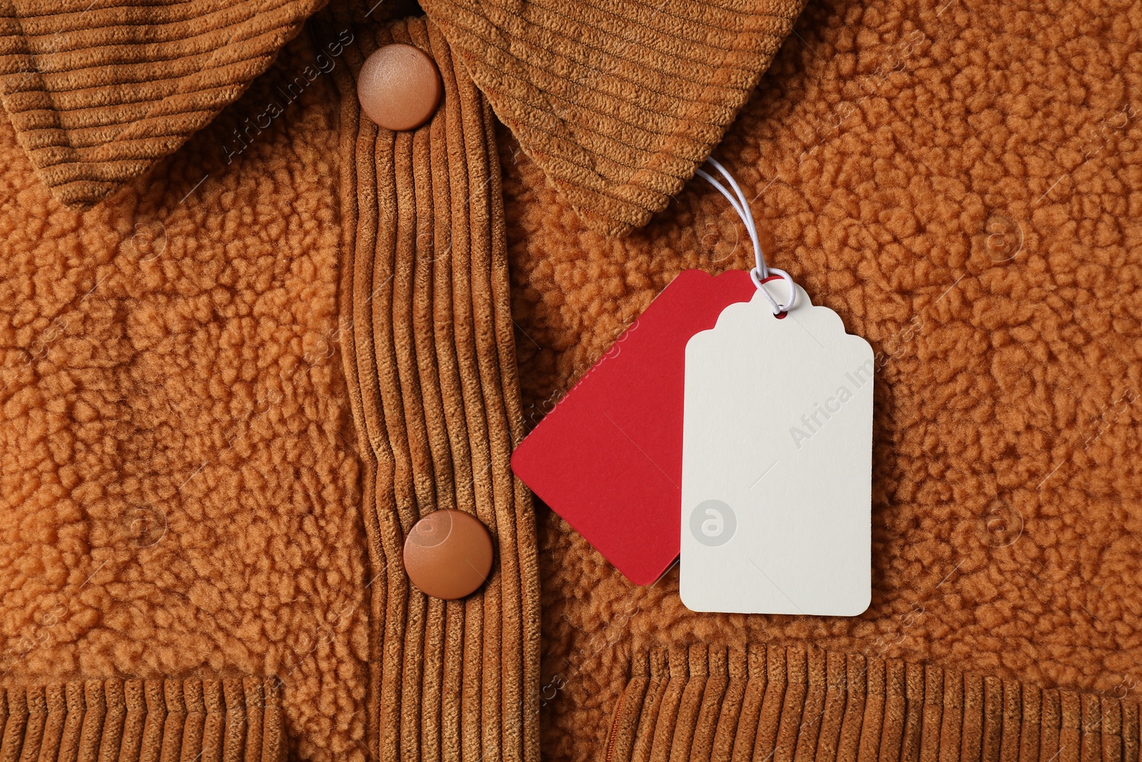 Cardboard tags on brown garment, top view Photo of Cardboard tags on brown garment, top view