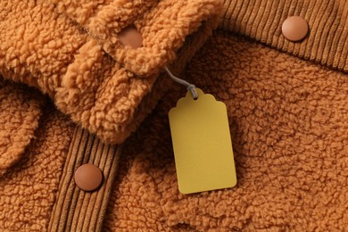 Photo of Cardboard tag on brown garment, top view