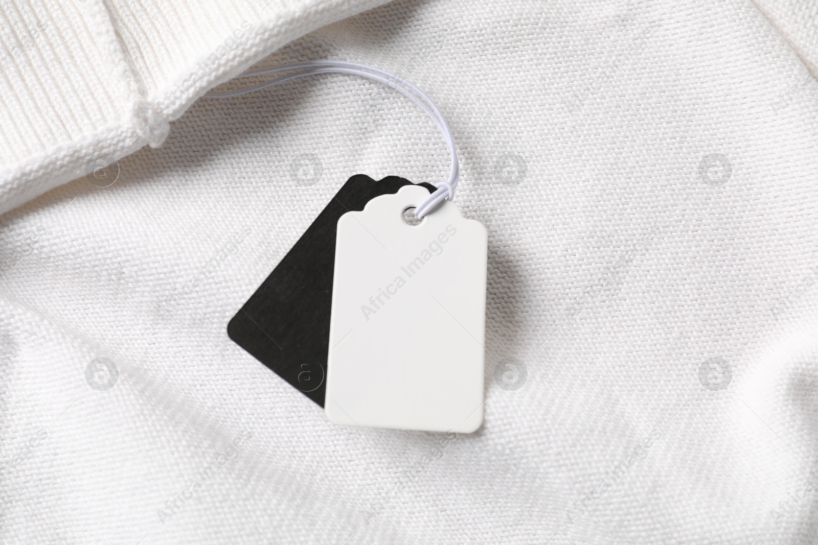 Cardboard tags on white garment, above view Photo of Cardboard tags on white garment, above view