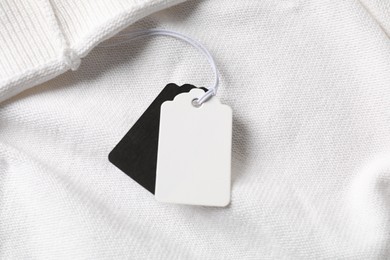 Photo of Cardboard tags on white garment, above view
