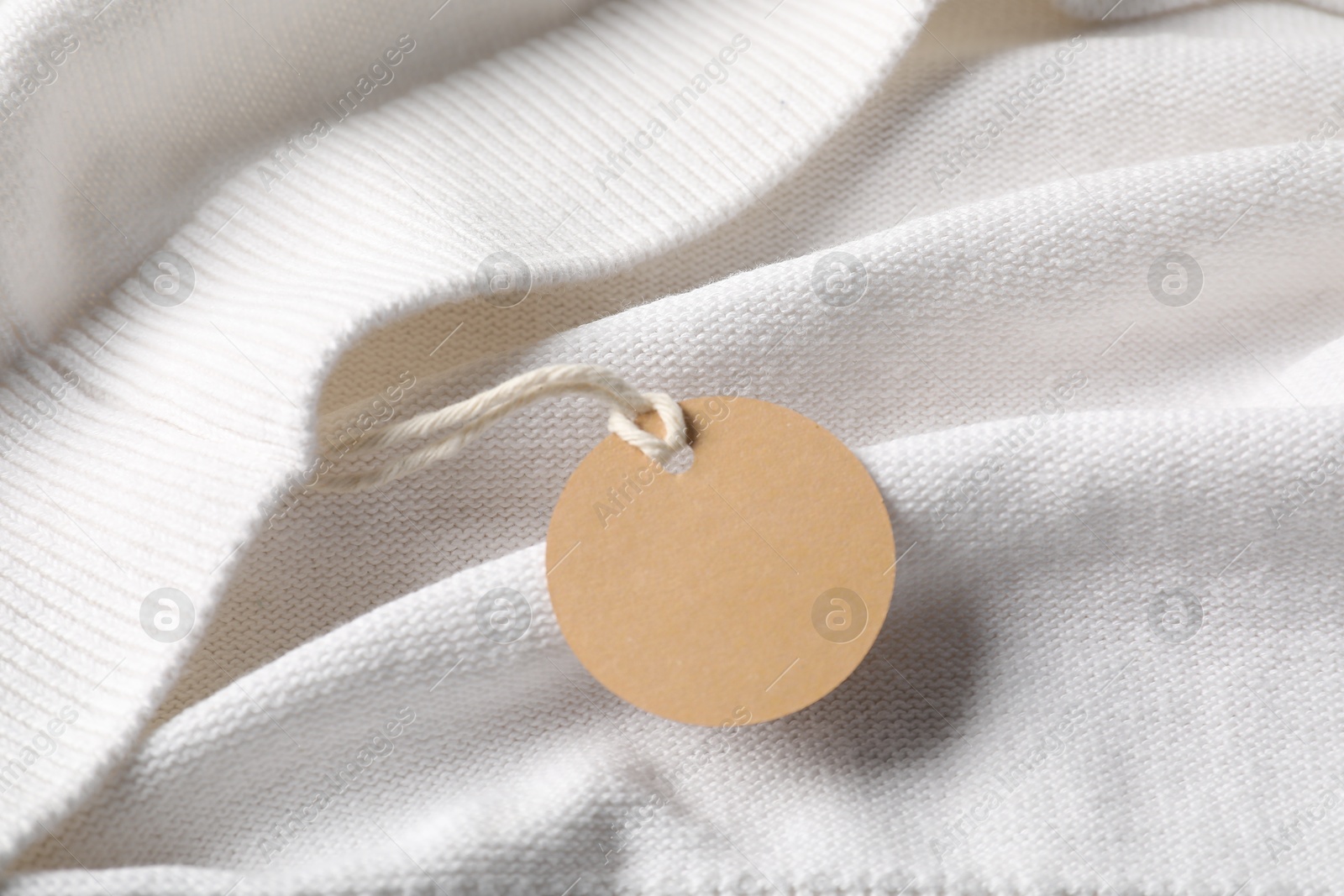 Cardboard tag on white garment, above view Photo of Cardboard tag on white garment, above view