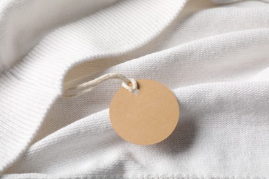 Photo of Cardboard tag on white garment, above view