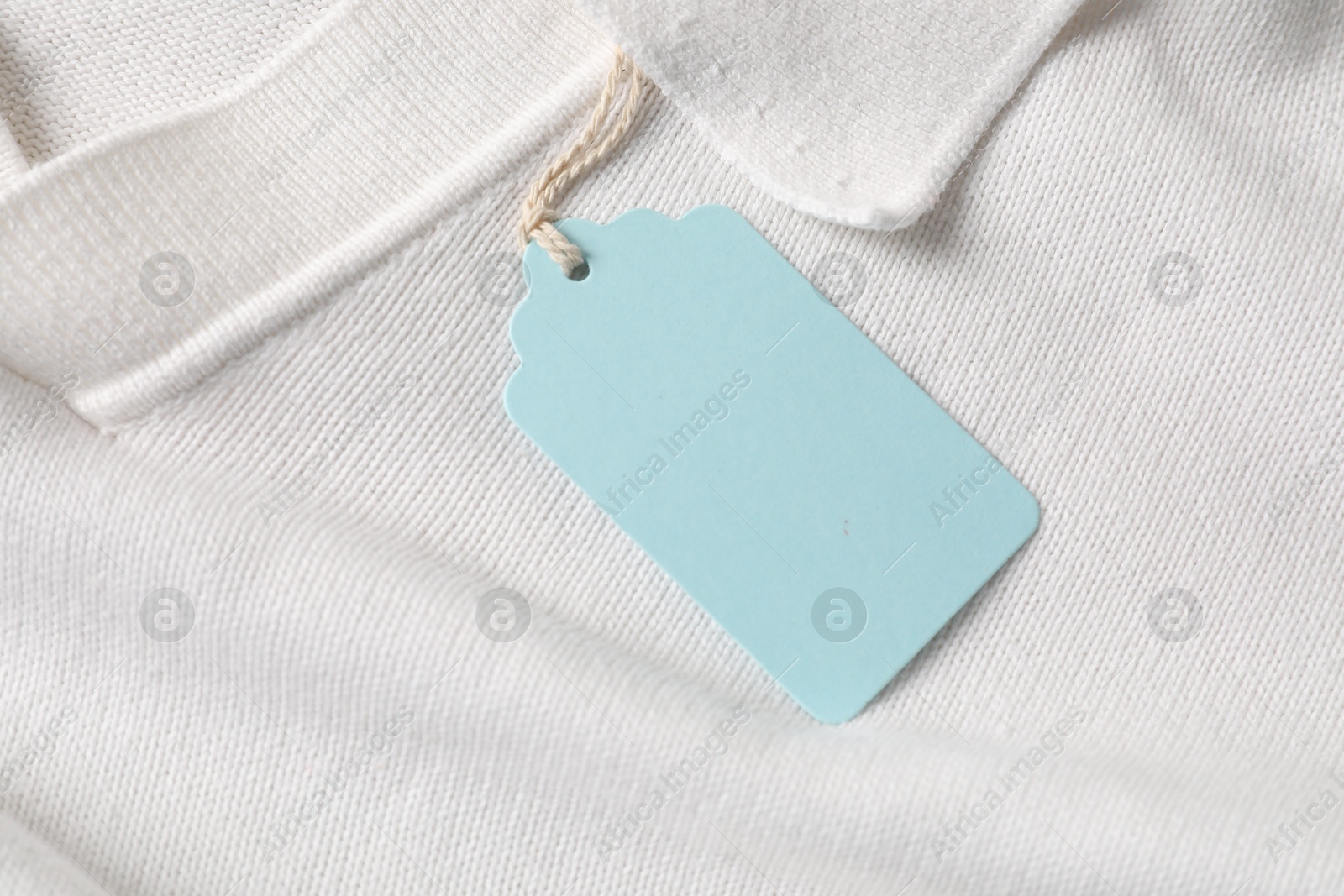 Cardboard tag on white garment, above view Photo of Cardboard tag on white garment, above view