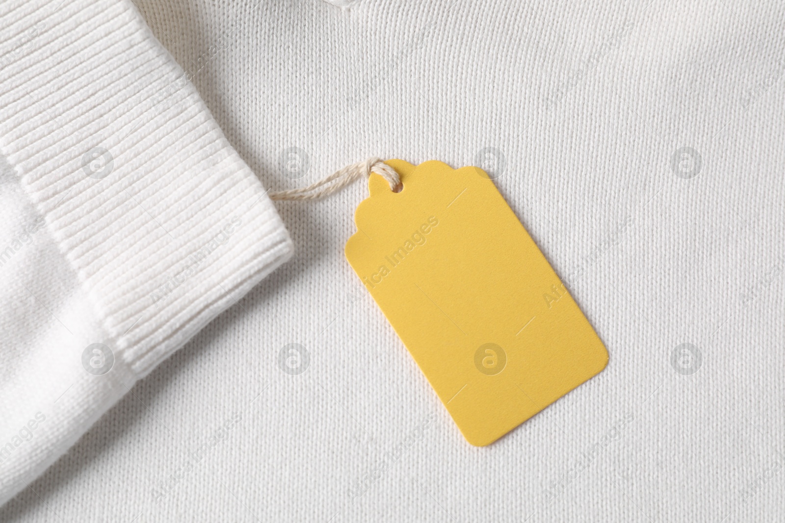 Cardboard tag on white garment, top view Photo of Cardboard tag on white garment, top view