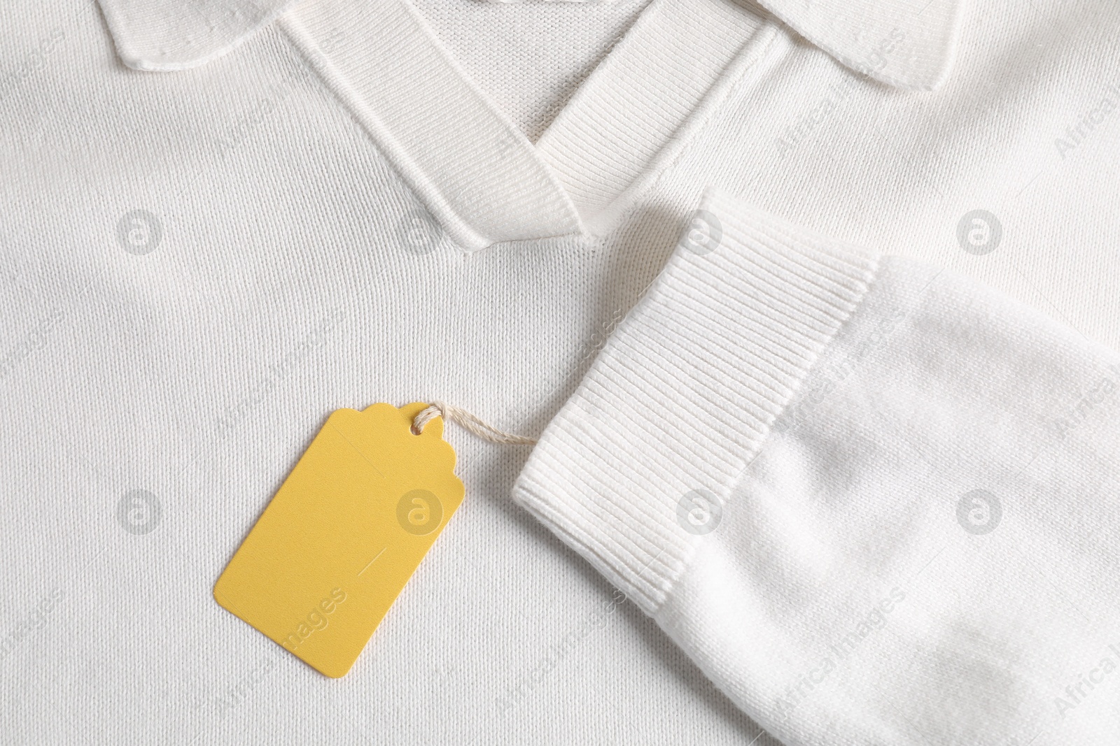 Cardboard tag on white garment, top view Photo of Cardboard tag on white garment, top view
