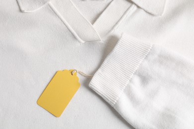 Photo of Cardboard tag on white garment, top view