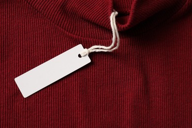 Photo of Cardboard tag on red garment, top view
