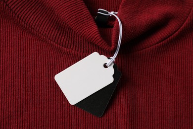 Photo of Cardboard tags on red garment, top view