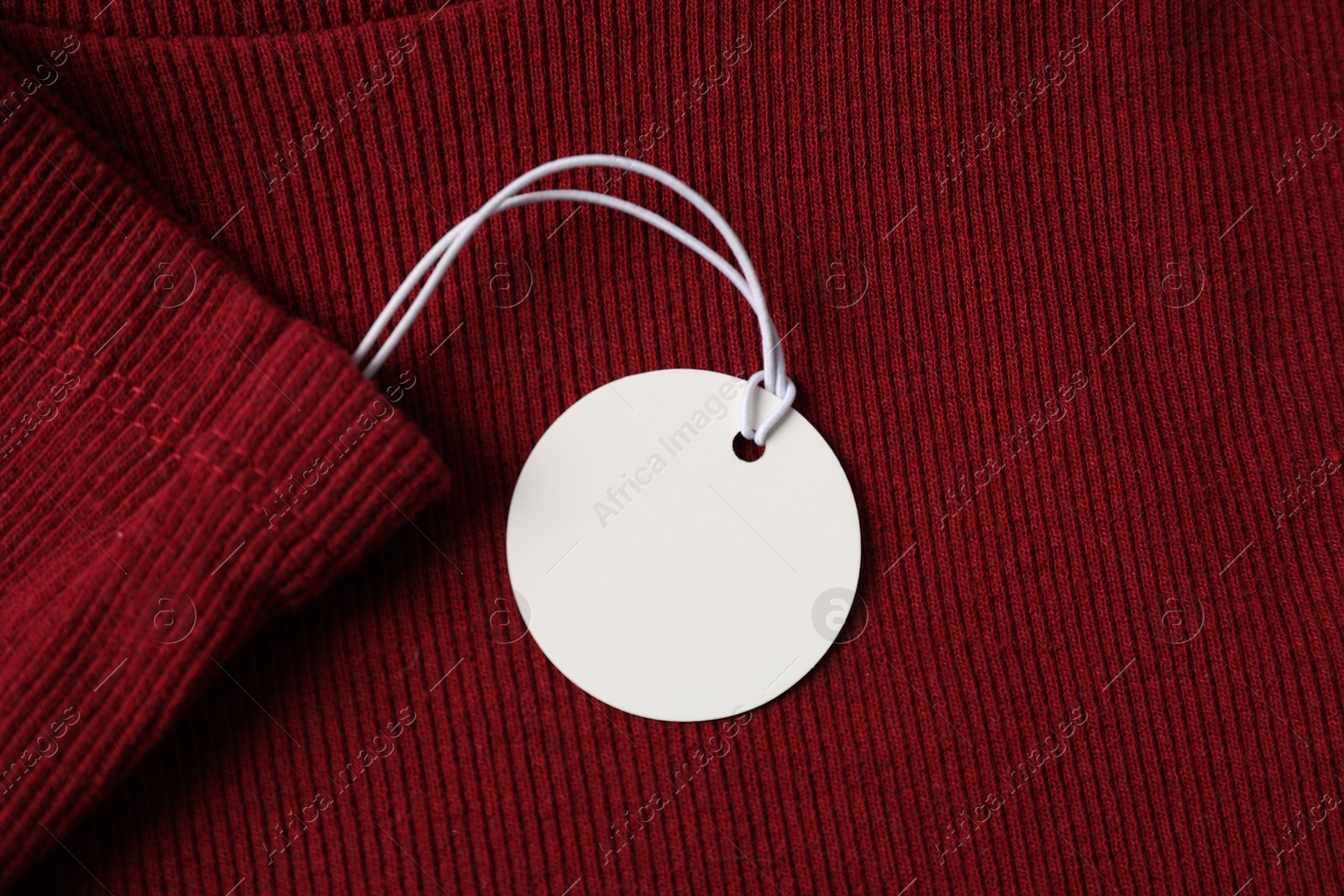 Cardboard tag on red garment, top view Photo of Cardboard tag on red garment, top view