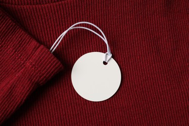 Photo of Cardboard tag on red garment, top view