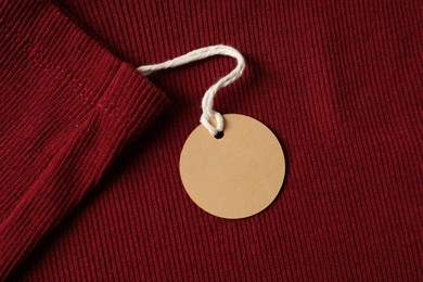 Photo of Cardboard tag on red garment, top view