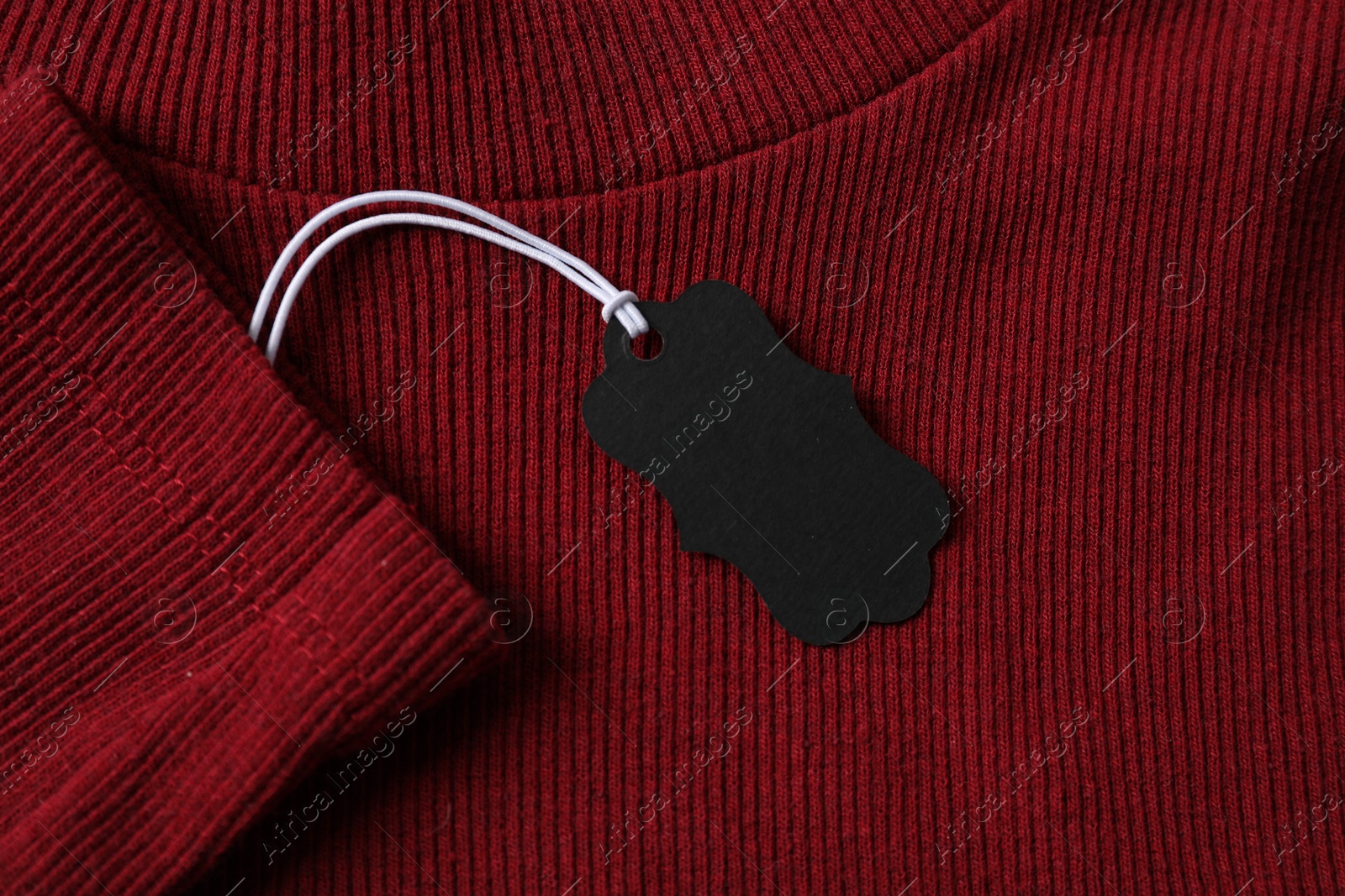 Cardboard tag on red garment, top view Photo of Cardboard tag on red garment, top view