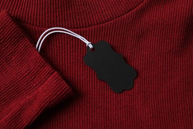 Photo of Cardboard tag on red garment, top view
