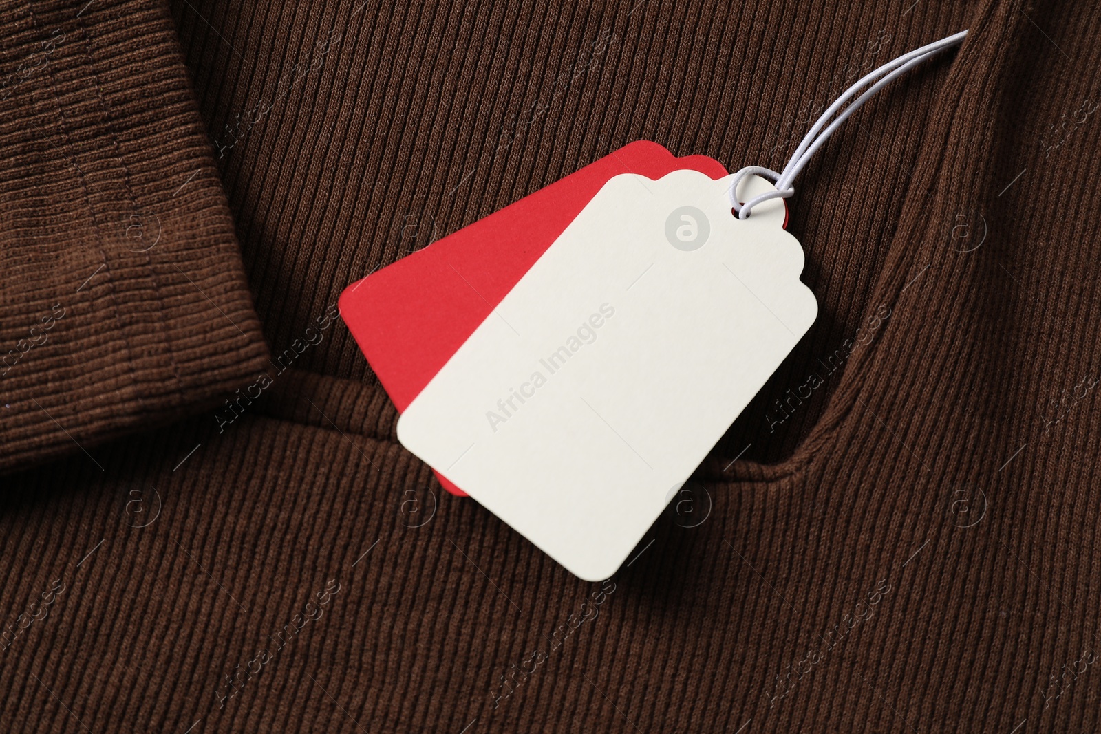 Cardboard tags on brown garment, above view Photo of Cardboard tags on brown garment, above view