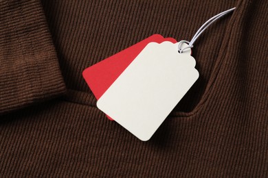 Photo of Cardboard tags on brown garment, above view